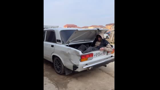 Person pushes out car dent with legs from inside boot