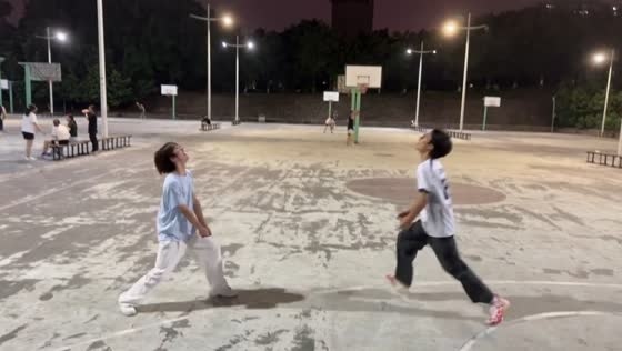 Friends repeatedly miss volleyball on basketball court in Chongqing, China