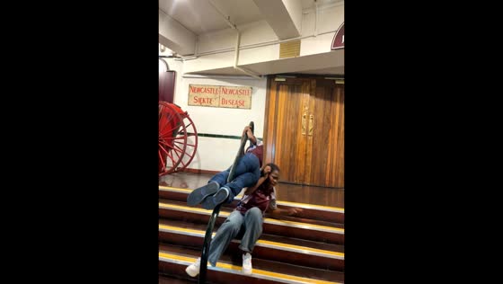 Woman loses balance while sitting on stair handrail in Johannesburg, South Africa