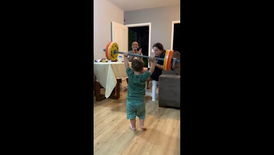 Young boy shows strength lifting barbell in Brasília, Brazil