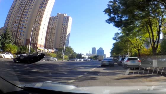 Black car overturns after colliding with a white car in Dalian, China