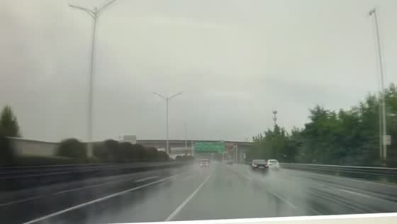 Black car loses control and crashes into roadside barrier on wet highway in Jiangsu, China