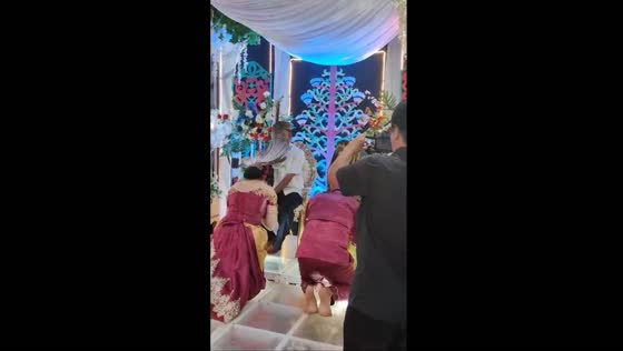 Traditional wedding mishap: bride's long head accessory amuses guests