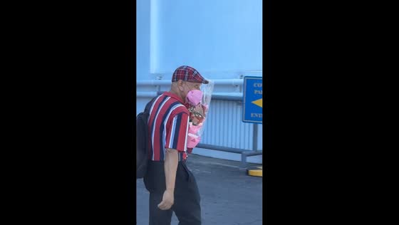 Elder man carries bouquet of flowers on the way home in Muntinlupa, Philippines