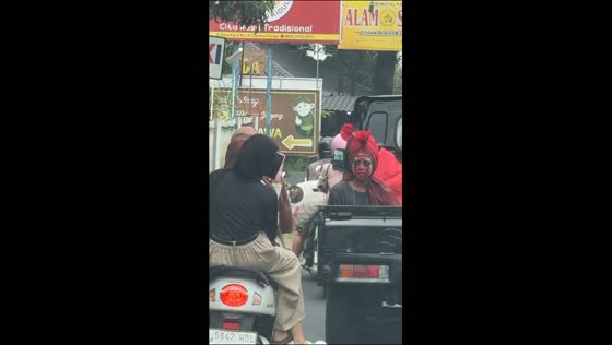 Costumed passenger startles motorcyclists from moving truck in Bogor, Indonesia