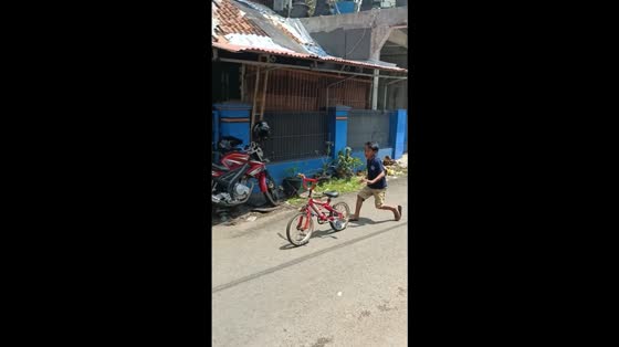 Riderless bike crashes into canal as kids laugh in Indonesia