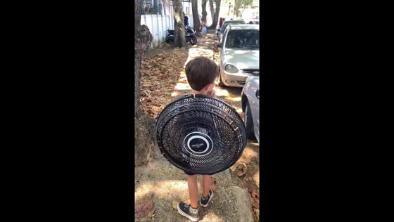 Boy carries school backpack made from an electric fan in Rio de Janeiro, Brazil