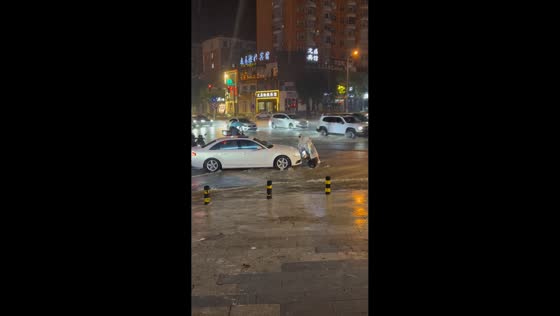 Scooter rider nearly hit by car while struggling through severe flooding in Shanxi, China