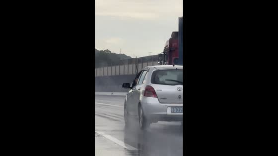 Driver manually wipes windshield with hand on highway in Guangdong, China