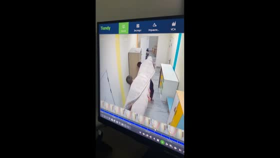 Man bumps head while carrying a carpet in Astana, Kazakhstan