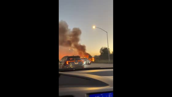 Brush fire burns alongside I-405 freeway in Hawthorne, California, USA