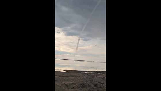 Waterspout rises from storm clouds over calm waters in Heilongjiang, China