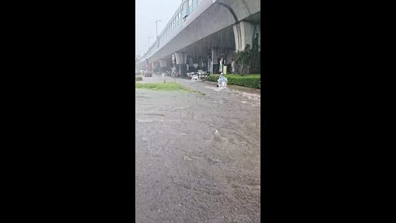 Flooded roadway under flyover disrupts traffic during heavy rain in Kunshan, China