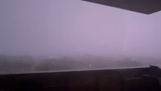Hailstorm with thunder and lightning in foggy night in Houston, Texas