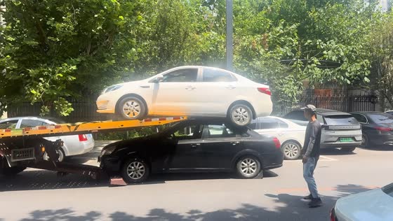 Tow truck uses stacked transport method to haul two sedans in Hebei, China 