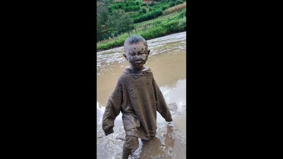 Children covered in mud after playing in Yunnan, China
