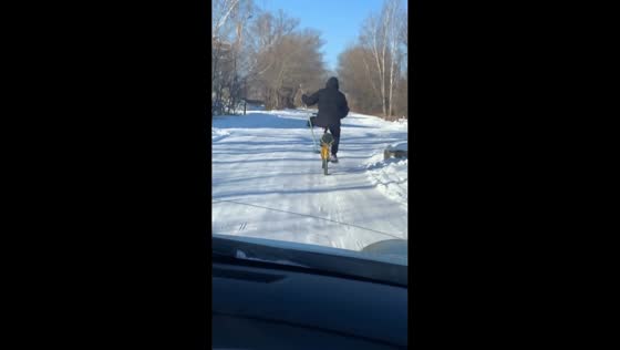 One-legged man rides bicycle using crutches in Nikolayevka, Russia
