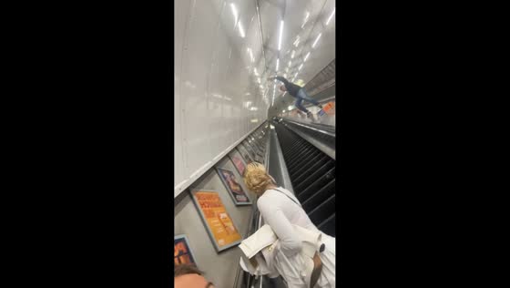 Man trips while running down escalator in London, England, UK