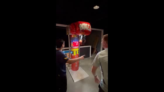 Man performs a Glasgow kiss at punching machine in Boston, USA