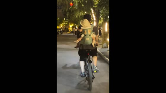 Father takes his seven-month-old baby on a bicycle ride at night in Shaanxi, China