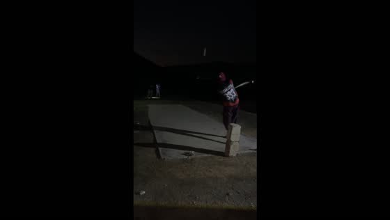 Cricket match continues under flashlights after a power outage in Haripur, Pakistan