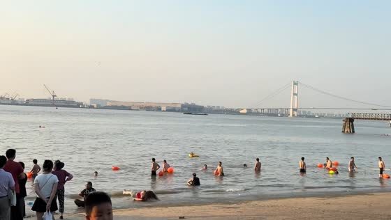 Woman slips into water but saves phone first at beach in Jiangsu, China