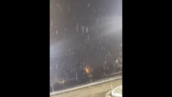 Gentle snow falls at night in Nicholasville, Kentucky, USA