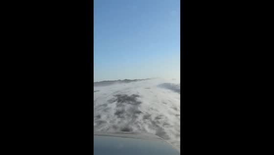 Wind-driven snow sweeps across roadway in wave-like patterns in Karamay, Xinjiang, China