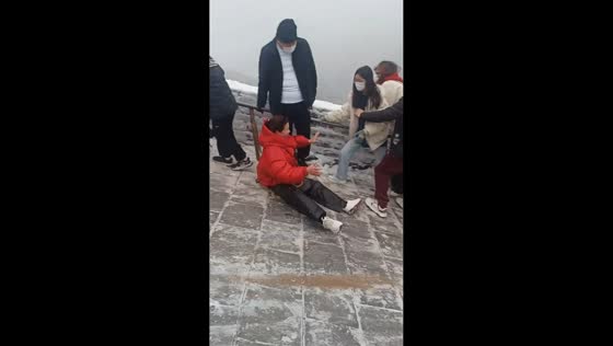 Woman slips on snowy slope of Great Wall in Hebei, China