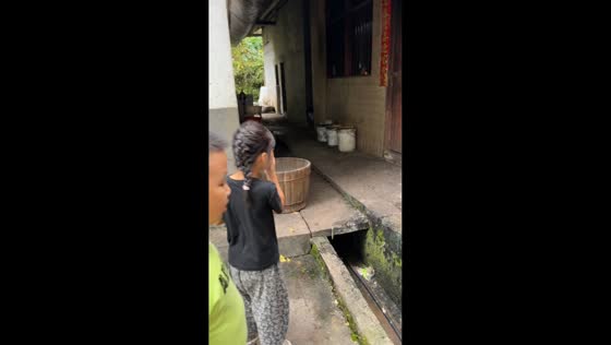 Girls get startled as pigs try to climb over their cage gate in Sichuan, China