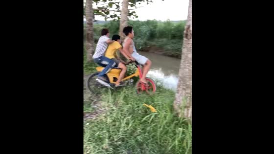 Three kids jump into a river from a motorcycle in Medan