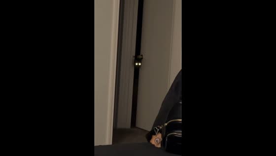 Cat peeks through doorway with glowing eyes in Tulsa, Oklahoma
