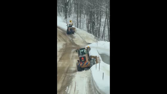 Snowplow clears rural road after overnight snowfall in Altmar, New York, USA