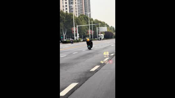 Meituan rider spotted riding a motorcycle in a reclined position on a busy road in Zhengzhou, China