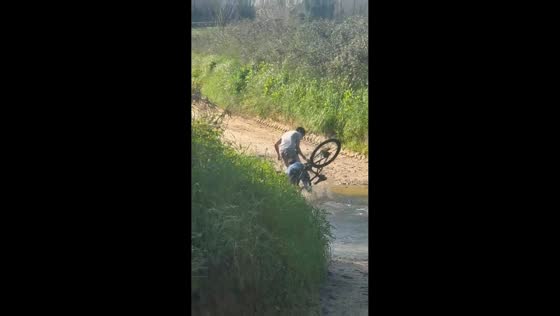 Two boys fall into water while riding bicycle in Riudellots de la Selva, Spain