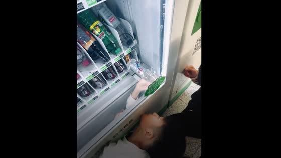 Boys retrieve stuck drinks from vending machine in Guangdong Province