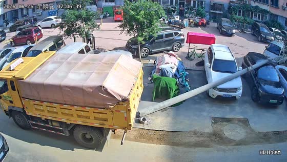 Reversing truck knocks down utility pole onto parked vehicles in Liaoning, China