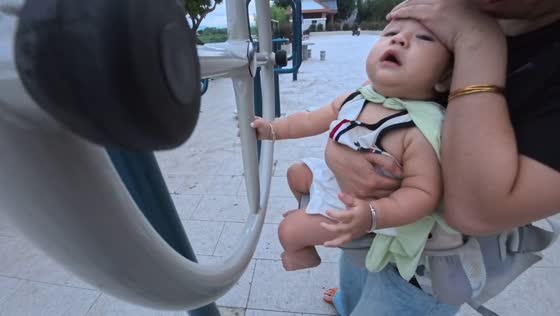 Baby bumps their head on an outdoor exercise machine in Guangdong, China