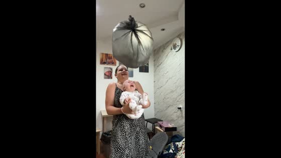 Baby giggles at bouncing bag with mother in Astana, Kazakhstan