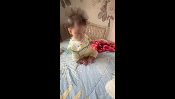 Sleepy toddler keeps lying back down on bed in Guangdong, China