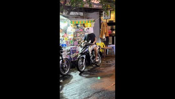 Dog rides on owner's lap during motorcycle stop in Guangdong, China
