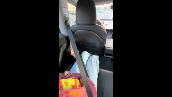 Backseat passenger pranks driver by taking his seatbelt in Boston, Massachusetts, USA