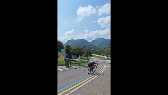 Cyclist ducks under lowered boom barrier in Hubei, China