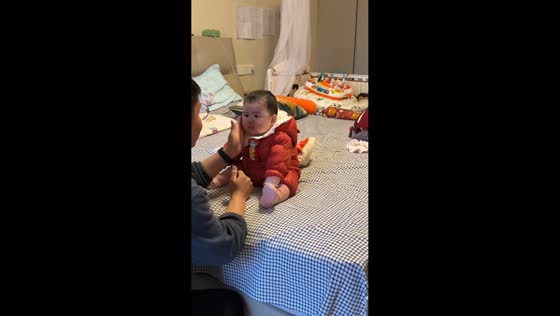 Child cries after playful hand slap moment with father in Jiangsu, China