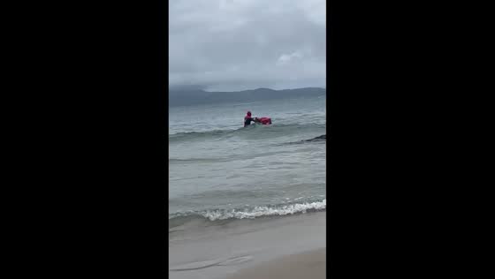 Street vendor dressed as Spiderman sells goods in the sea in Santa Catarina, Brazil
