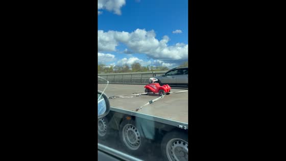 Toy car spotted strapped on trailer behind pickup in Stockholm, Sweden