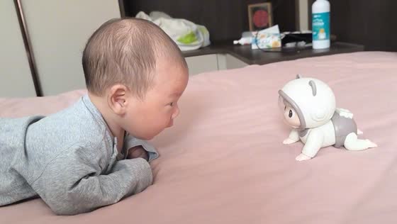 Child observes crawling toy in Shandong China