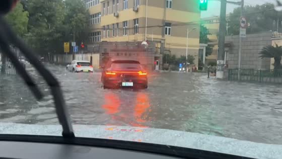 Driver turns around after encountering a flooded road in Shanghai, China