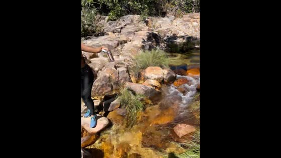 Woman slips while crossing a stream in Cavalcante, Brazil