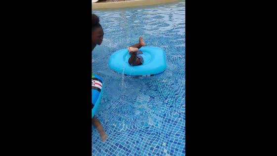 Toddler twins flip in baby floaters during first pool experience in Mombasa, Kenya